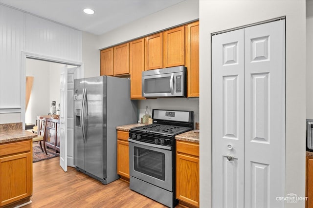 kitchen featuring appliances with stainless steel finishes and light hardwood / wood-style flooring