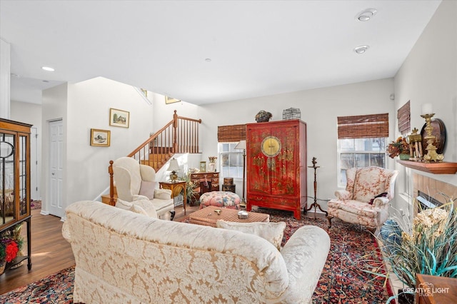 living room featuring a brick fireplace and hardwood / wood-style flooring