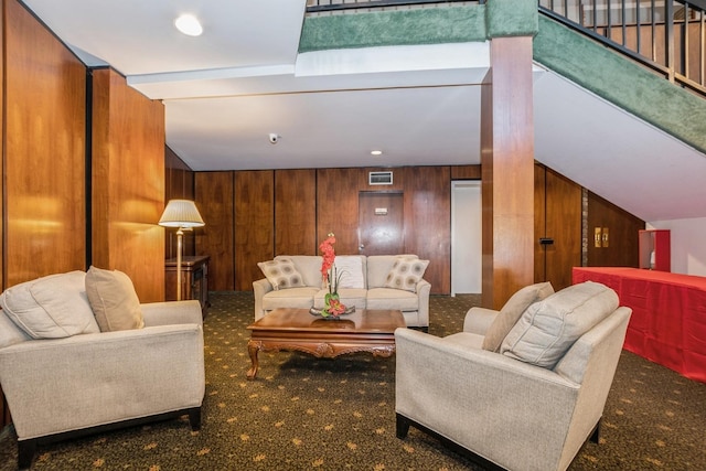 carpeted living room with wood walls