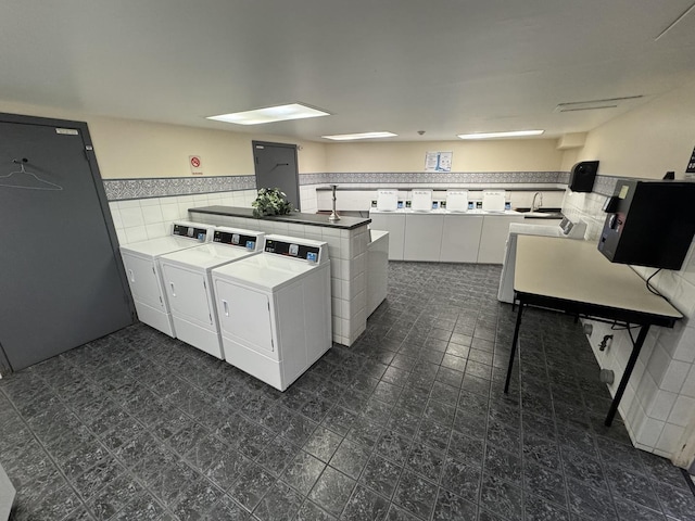 kitchen with tile walls, white cabinets, kitchen peninsula, and separate washer and dryer