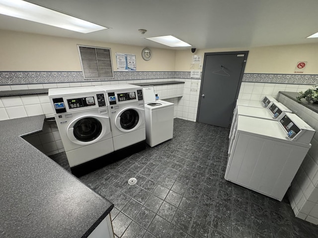 laundry room with tile walls and independent washer and dryer