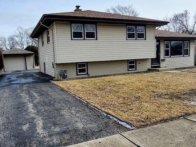 view of front of house with a garage and an outbuilding