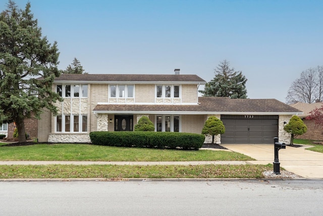 view of front facade with a garage and a front lawn