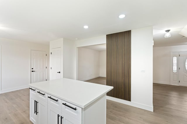 kitchen featuring white cabinets, a kitchen island, and light hardwood / wood-style floors