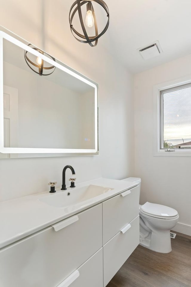 bathroom with hardwood / wood-style floors, vanity, and toilet