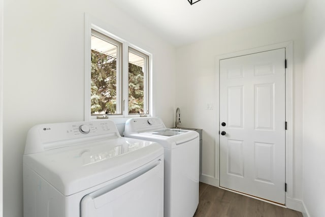 laundry room with dark hardwood / wood-style flooring, separate washer and dryer, and sink