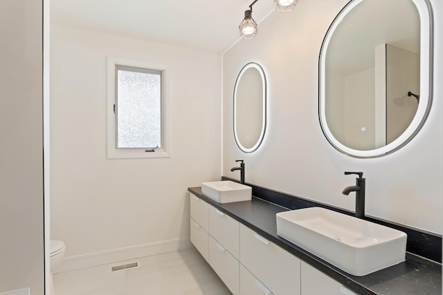 bathroom featuring tile patterned floors, vanity, and toilet