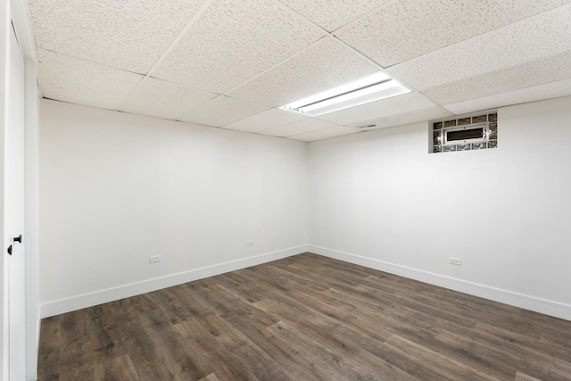 basement featuring a drop ceiling and dark hardwood / wood-style floors