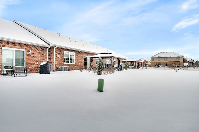 snowy yard featuring a gazebo and central air condition unit