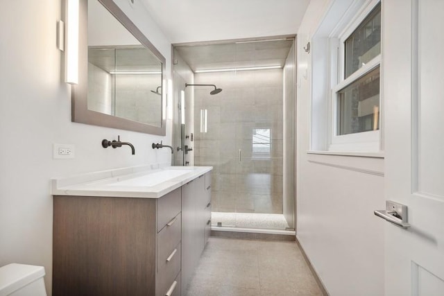 bathroom featuring toilet, vanity, and walk in shower