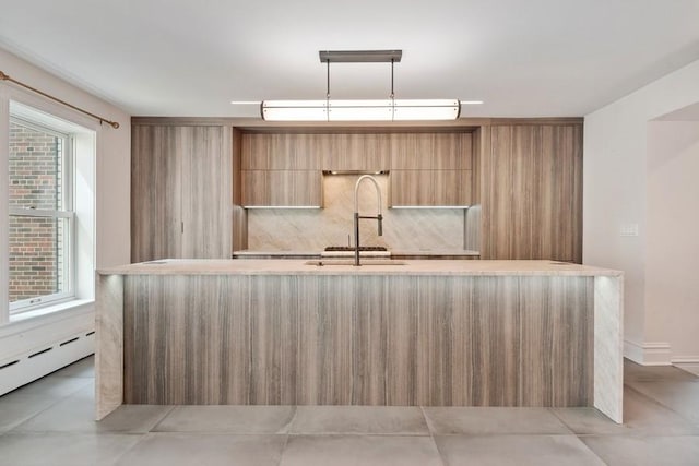 kitchen with pendant lighting, baseboard heating, and sink