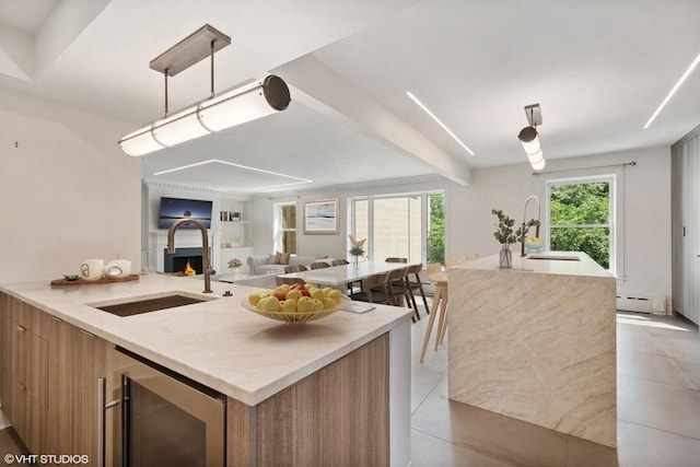 kitchen with light tile patterned floors, wine cooler, baseboard heating, and sink