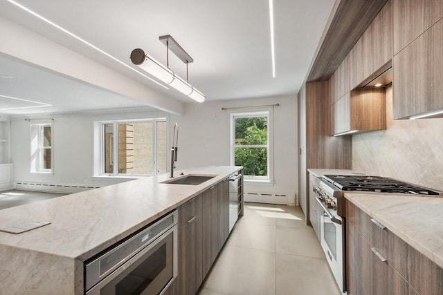 kitchen with backsplash, a baseboard heating unit, sink, hanging light fixtures, and stainless steel appliances