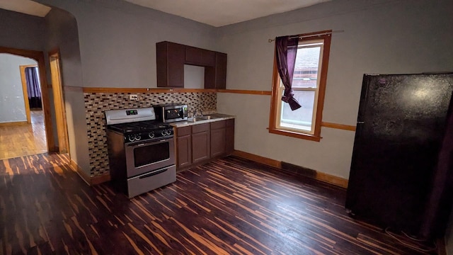 kitchen with dark hardwood / wood-style flooring, stainless steel appliances, and tasteful backsplash