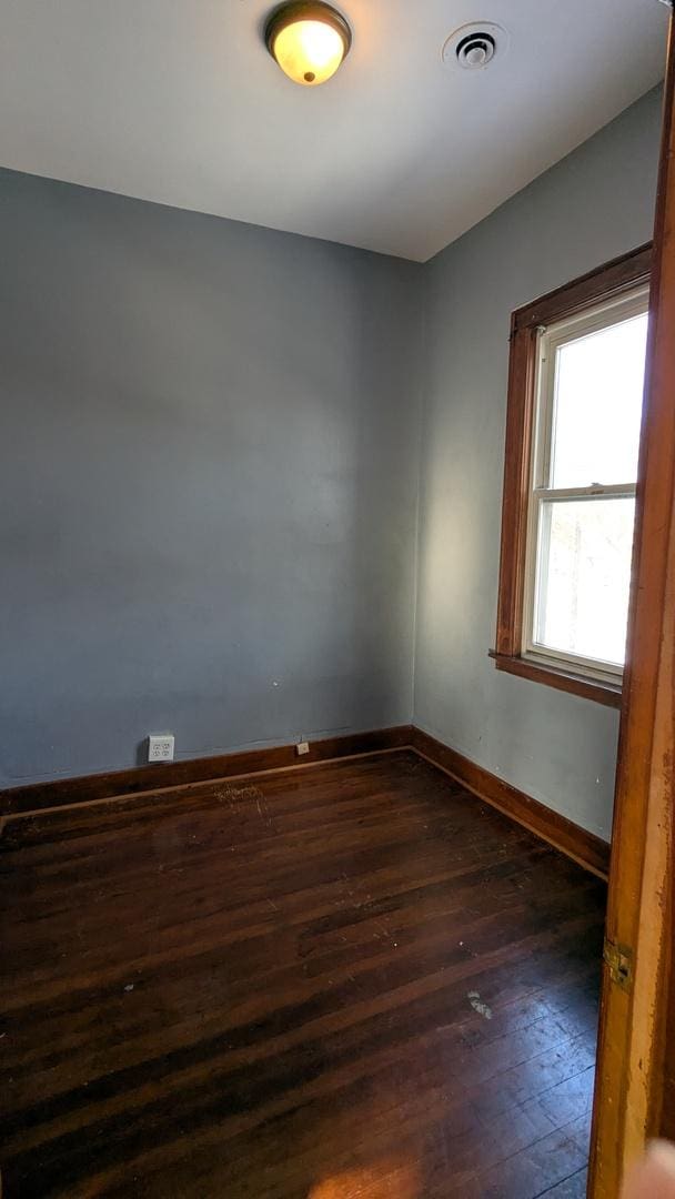 unfurnished room featuring dark wood-type flooring