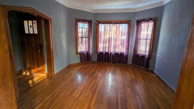 empty room featuring hardwood / wood-style floors and ornamental molding