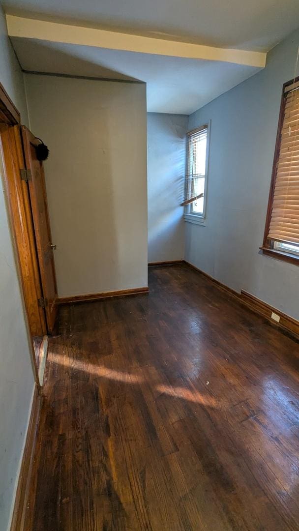 unfurnished room featuring dark wood-type flooring