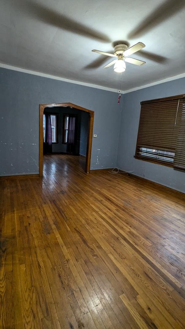 unfurnished room featuring ceiling fan, crown molding, and dark hardwood / wood-style floors