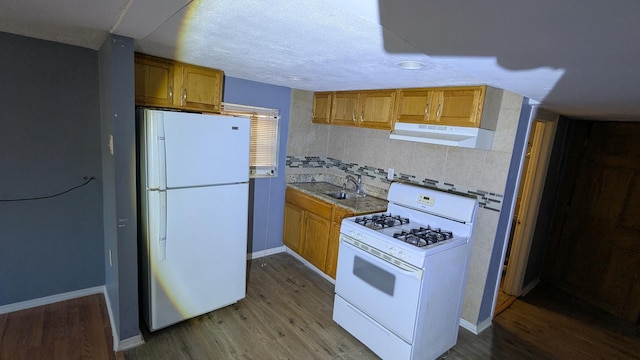 kitchen with sink, a textured ceiling, white appliances, light hardwood / wood-style floors, and backsplash