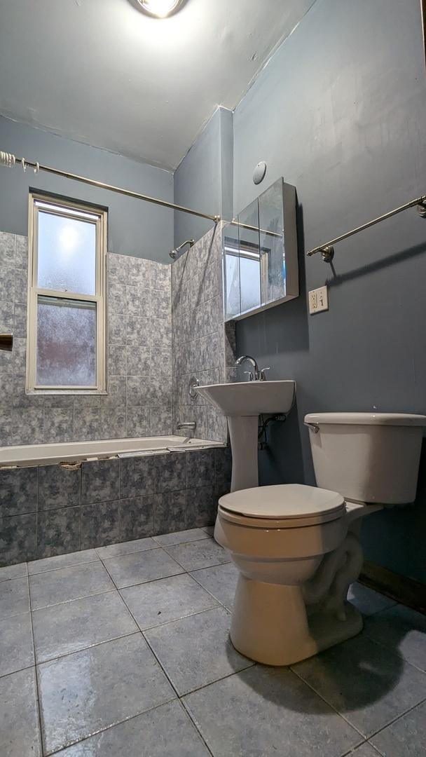 bathroom featuring toilet and tiled shower / bath