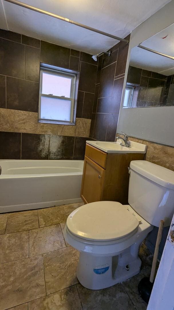 full bathroom with toilet, vanity, and tiled shower / bath