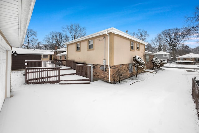 snow covered property with a wooden deck