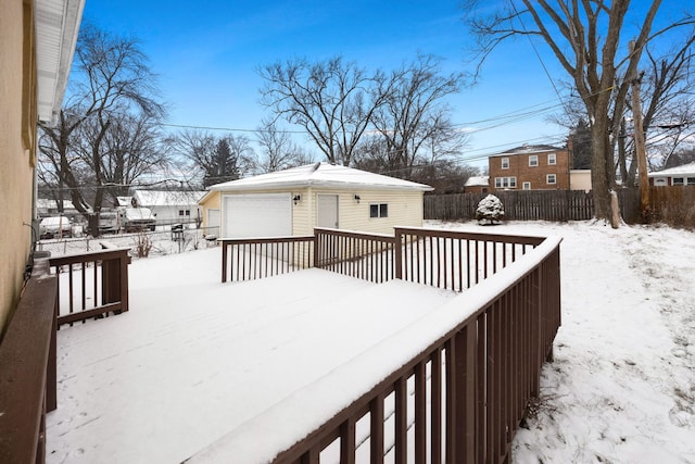 snow covered deck with an outbuilding and a garage