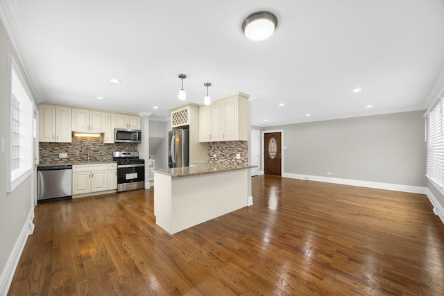 kitchen featuring sink, stainless steel appliances, tasteful backsplash, kitchen peninsula, and pendant lighting