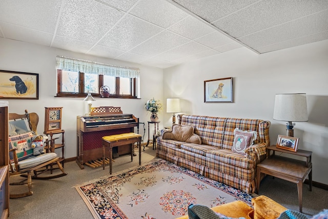 living room featuring carpet flooring and a drop ceiling