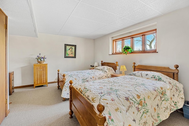 bedroom featuring carpet floors and a paneled ceiling