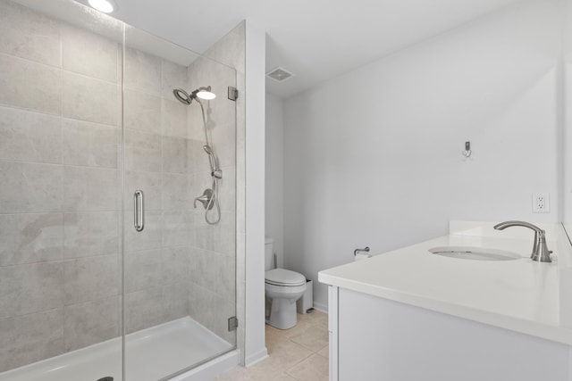 bathroom with toilet, vanity, tile patterned floors, and a shower with door