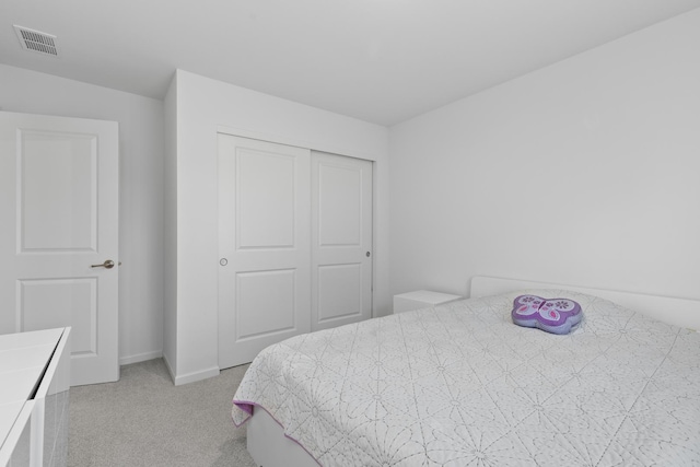 bedroom featuring light colored carpet and a closet