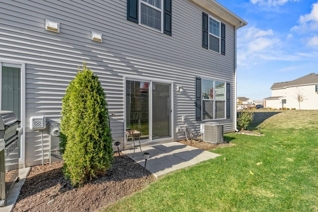 back of property featuring a lawn and central AC unit