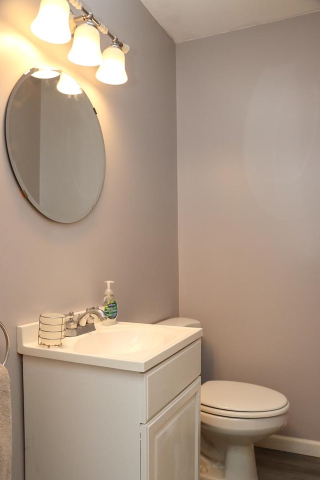 bathroom with hardwood / wood-style flooring, vanity, and toilet