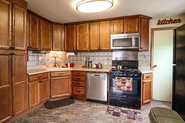 kitchen featuring dishwasher, black gas range, tasteful backsplash, and sink