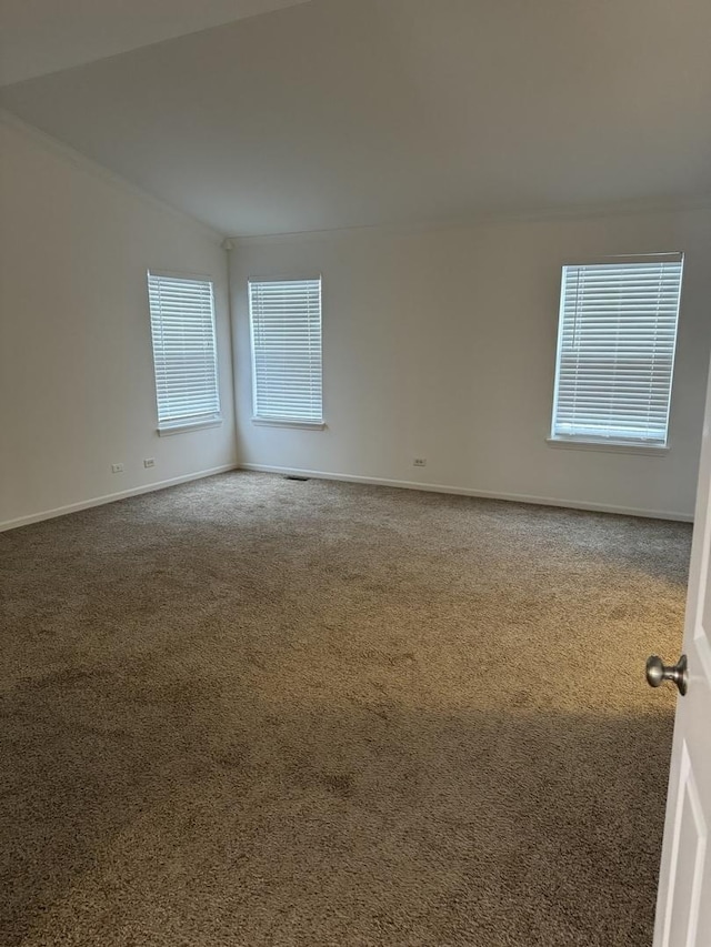 unfurnished room featuring carpet and lofted ceiling