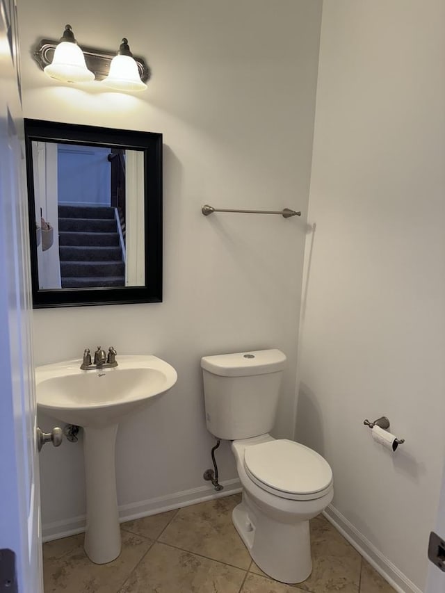 bathroom featuring sink, toilet, and tile patterned flooring