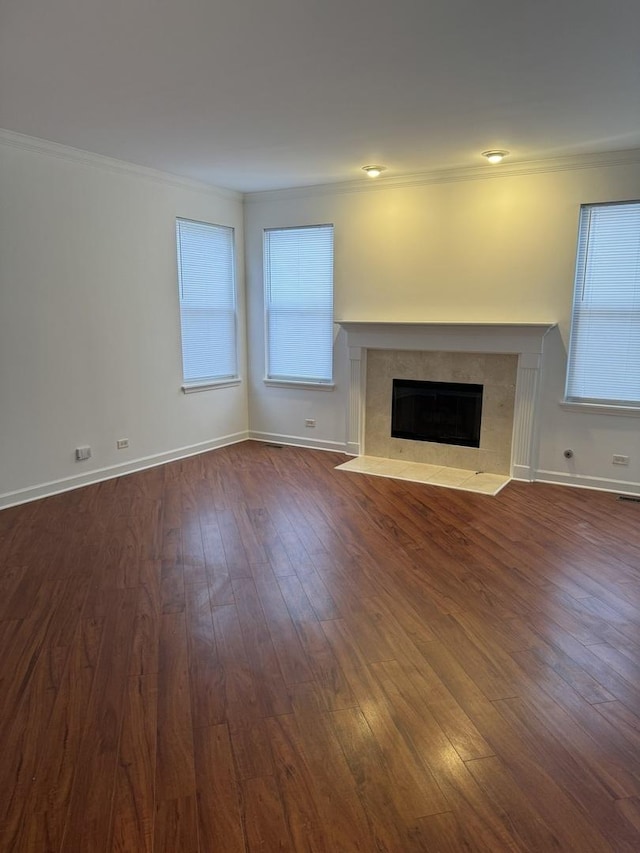 unfurnished living room featuring dark hardwood / wood-style flooring, crown molding, and a premium fireplace