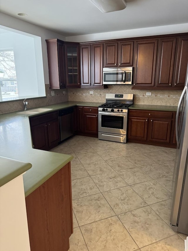 kitchen featuring light tile patterned floors, appliances with stainless steel finishes, sink, and dark brown cabinetry