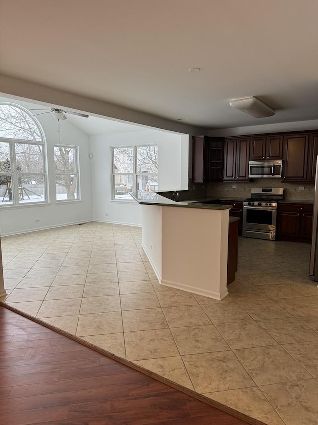 kitchen with ceiling fan, dark brown cabinetry, light tile patterned floors, and stainless steel appliances