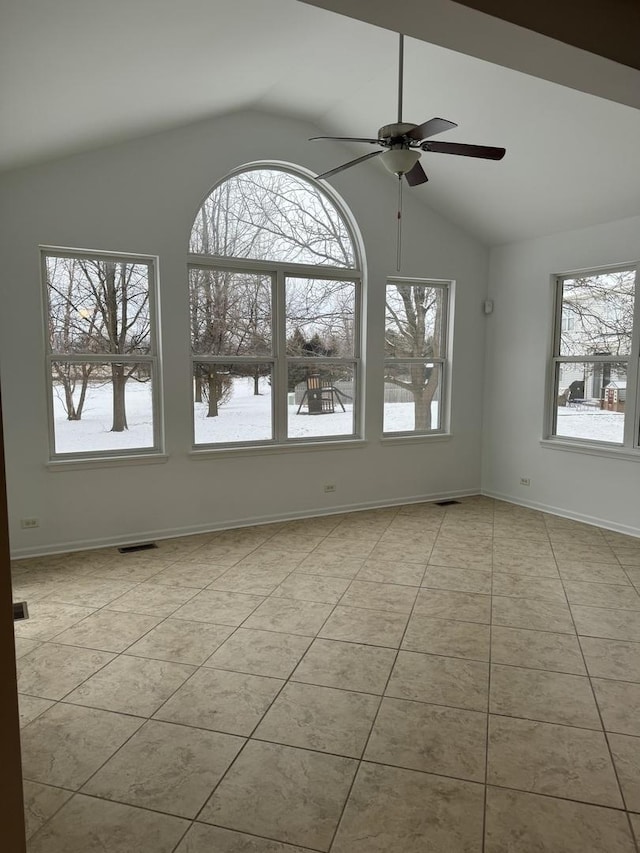 spare room featuring ceiling fan, light tile patterned floors, and vaulted ceiling