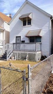 rear view of house with a fenced front yard and a gate