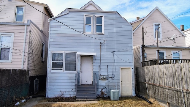 rear view of property with entry steps, cooling unit, and a fenced backyard