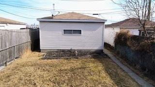 view of side of property with a lawn, an outdoor structure, and a fenced backyard