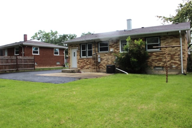 rear view of property featuring a lawn and a patio