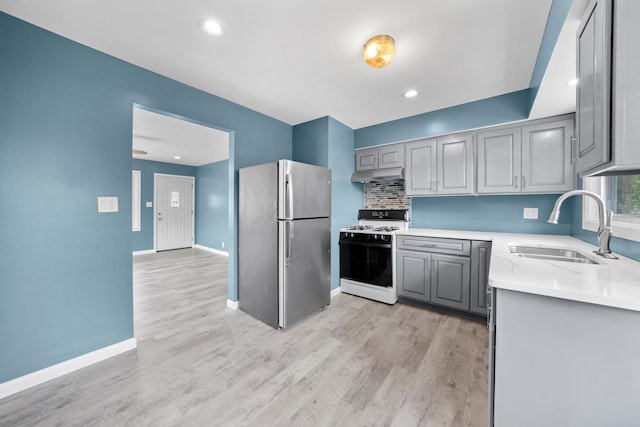 kitchen with gray cabinetry, sink, range with gas cooktop, and stainless steel refrigerator