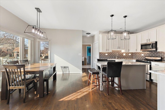 kitchen with pendant lighting, appliances with stainless steel finishes, and white cabinets