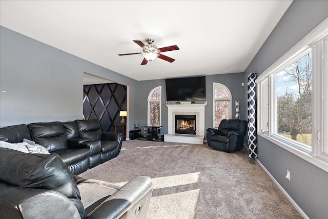 living room featuring a fireplace, carpet floors, and ceiling fan