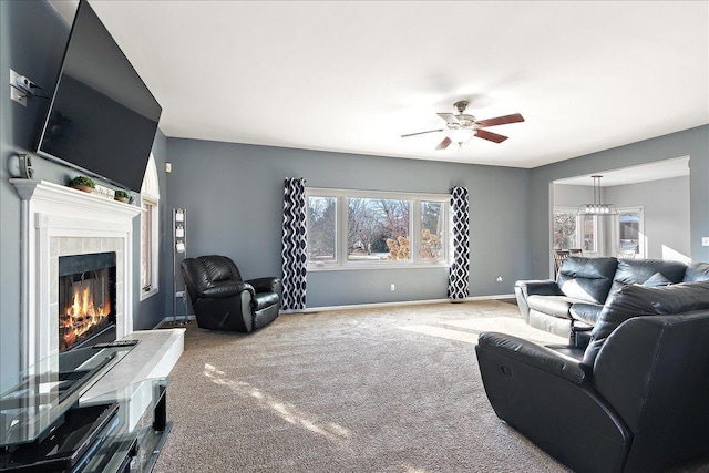 carpeted living room featuring ceiling fan and a tiled fireplace