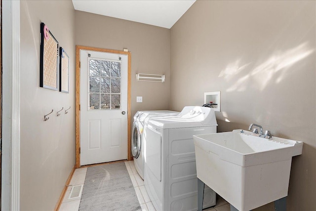 laundry room with sink, light tile patterned floors, and washing machine and clothes dryer